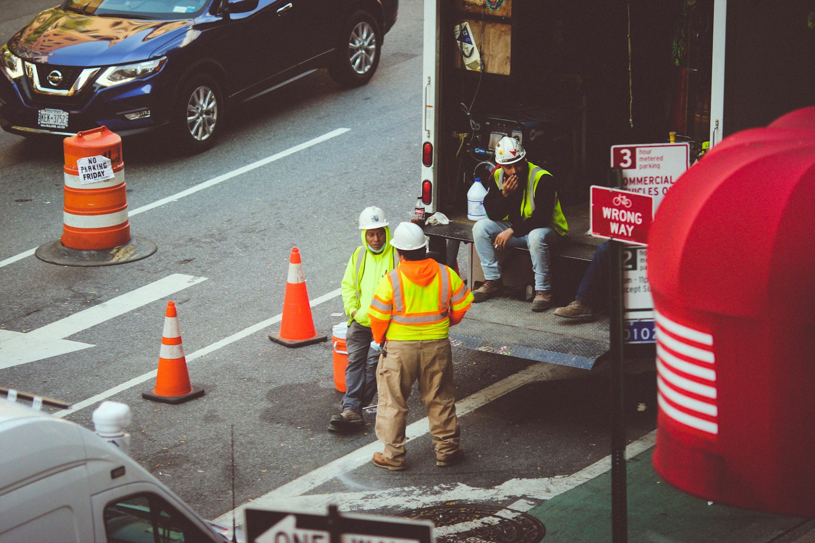 man in green jacket and gray pants walking on pedestrian lane during daytime