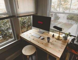 silver iMac, Magic Mouse, and wireless keyboard on desk neaar windows