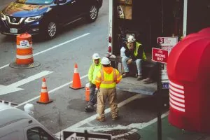 man in green jacket and gray pants walking on pedestrian lane during daytime